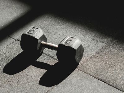 Dumbbells on a black floor with green reflection